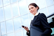 Young business lady outside with mobile phone