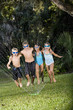 Photo: Children running through lawn sprinkler together Children running through lawn sprinkler together