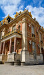Versailles Palace facade and golden fence over blue sky. France