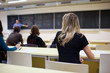 young pretty female college student sitting in a classroom full