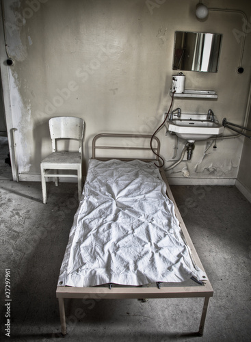 Photo: A bed sitting in a room of an abandoned hospital A bed sitting in a room of an abandoned hospital