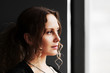 Young woman looking through a window.