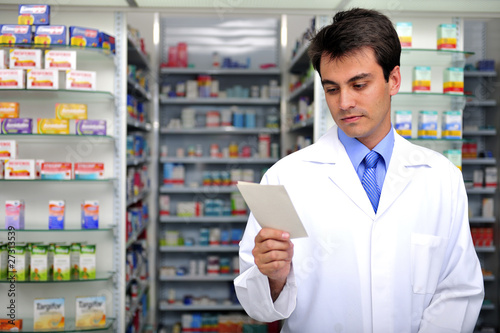 Photo: pharmacist reading prescription at pharmacy pharmacist reading prescription at pharmacy
