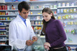 Pharmacist advising client at pharmacy