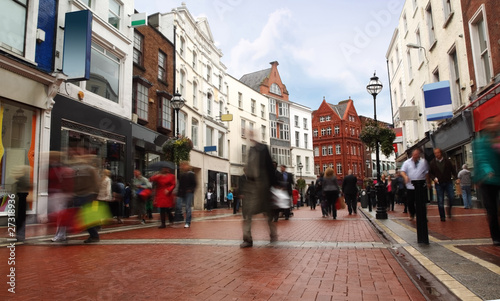 Photo: people quickly going on small, narrow street in cloudy weather people quickly going on small, narrow street in cloudy weather