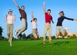 group of young people jumping outdoors grass group of young people jumping outdoors grass