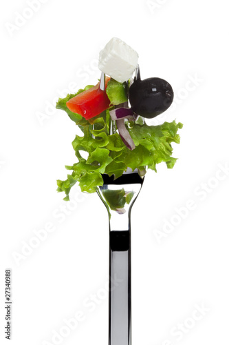 Foto: frischer griechischer salat auf einer gabel, isoliert frischer griechischer salat auf einer gabel, isoliert