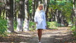 Young woman walking in park.