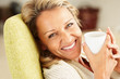 Closeup shot of a cheerful woman with a tea cup smiling Closeup shot of a cheerful woman with a tea cup smiling