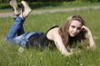 Young women lying on green grass in dandelions Young women lying on green grass in dandelions