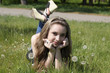 Young women lying on green grass in dandelions Young women lying on green grass in dandelions
