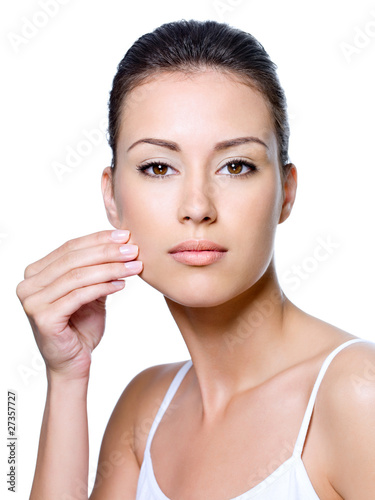 Photo: Woman pinching skin on her cheek - isolated Woman pinching skin on her cheek - isolated