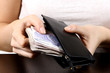 Young Woman Putting Money in Purse. Model Released