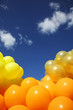 Inflatable yellow helium balloons on blue sky background Inflatable yellow helium balloons on blue sky background