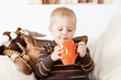 Baby boy drinking from a big jar