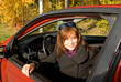 The girl sits in the red car