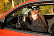 The girl with a key sits the red car