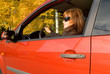The girl with sunglass sits in the red car