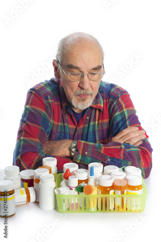 Photo: elderly man looking at his meds elderly man looking at his meds