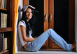 pretty woman is sitting on window with book on head