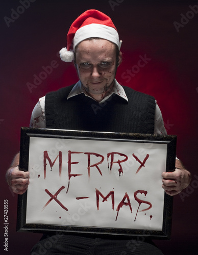 Foto: Horror Christmas Elf holding a sign written with blood. Horror Christmas Elf holding a sign written with blood.