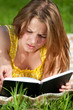 Beautiful young woman reading book outdoor