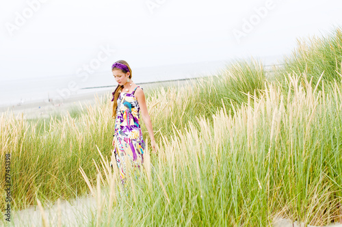 Photo: Model girl walking in sand dunes beach Model girl walking in sand dunes beach