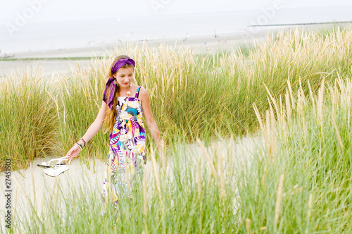 Photo: Model girl walking in sand dunes beach Model girl walking in sand dunes beach
