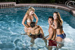 Two couples in swimming pool at night Two couples in swimming pool at night