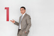 Successful businessman showing number one painted on wall Successful businessman showing number one painted on wall