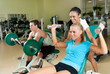 Young women lifting a dumb-bell with her trainer Young women lifting a dumb-bell with her trainer