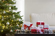 presents by christmas tree in modern living room