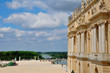 Versailles Palace facade and golden fence over blue sky
