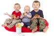 Three boys have fun while eating cookies Three boys have fun while eating cookies