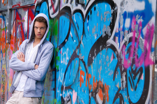 Foto: Cool blickender Jugendlicher Mann vor Graffiti Cool blickender Jugendlicher Mann vor Graffiti