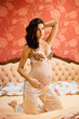 Pregnant woman sitting on a bed