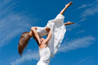 young couple dancing on sky background, freedom and relax symbol