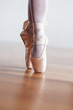Dancer in ballet shoes dancing in Pointe on wooden floor Dancer in ballet shoes dancing in Pointe on wooden floor