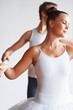 Ballerina with her trainer dancing against white background