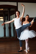 Two young ballet dancers practicing on wooden floor