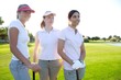 Golf three woman in a row green grass course Golf three woman in a row green grass course