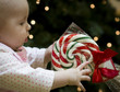 Baby reaching for Christmas Candy Cane Lollipop