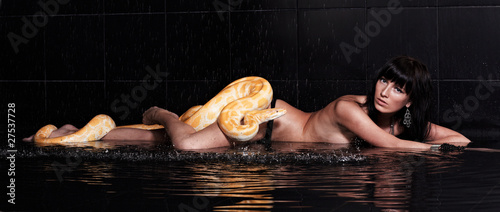 Photo: Beautiful woman lying with Python in water Beautiful woman lying with Python in water