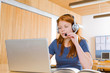 Young woman with headphones studying at desk