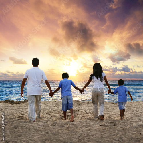 Photo: Family walking on the beach at sunset Family walking on the beach at sunset