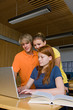 Teens studying with a computer in the library