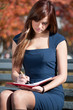 business woman reviewing diary at city park