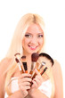 Beautiful young blonde woman with bright make-up and many brushe Beautiful young blonde woman with bright make-up and many brushe