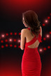 Elegant girl in a red dress on a black background with the light Elegant girl in a red dress on a black background with the light