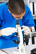 close-up of scientist looking through microscope
